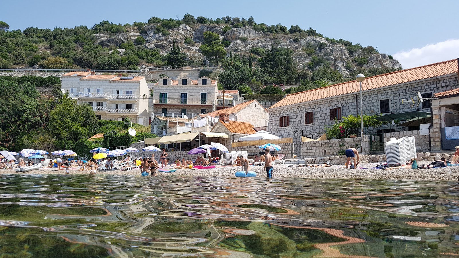 Foto af Stikovica beach bakket op af klipperne