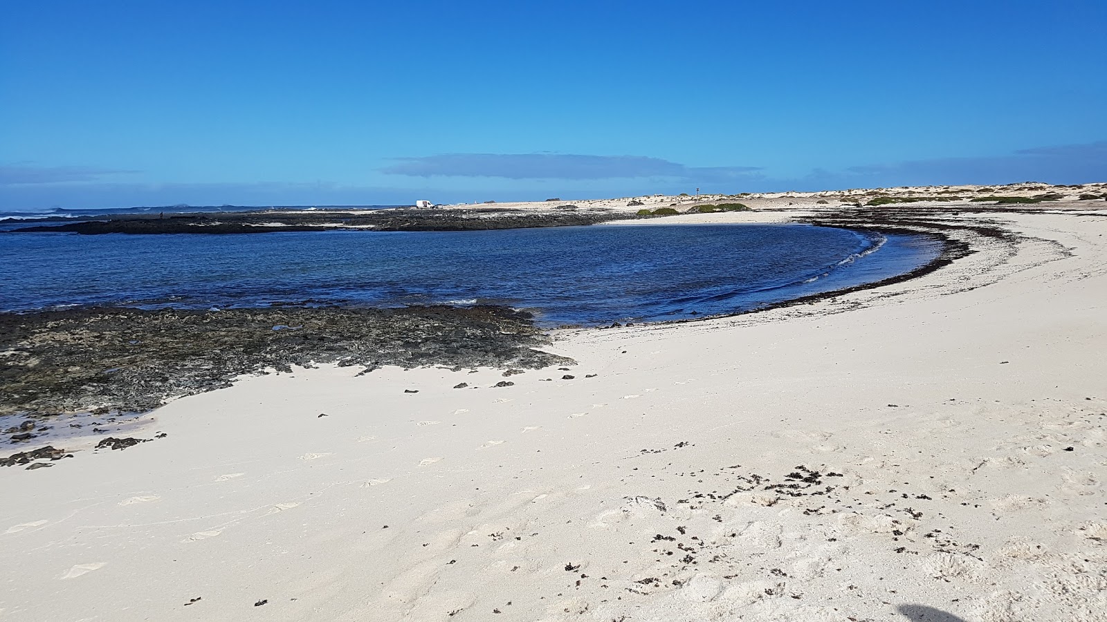 Foto di Playa Los Charcos II con una superficie del sabbia luminosa e rocce