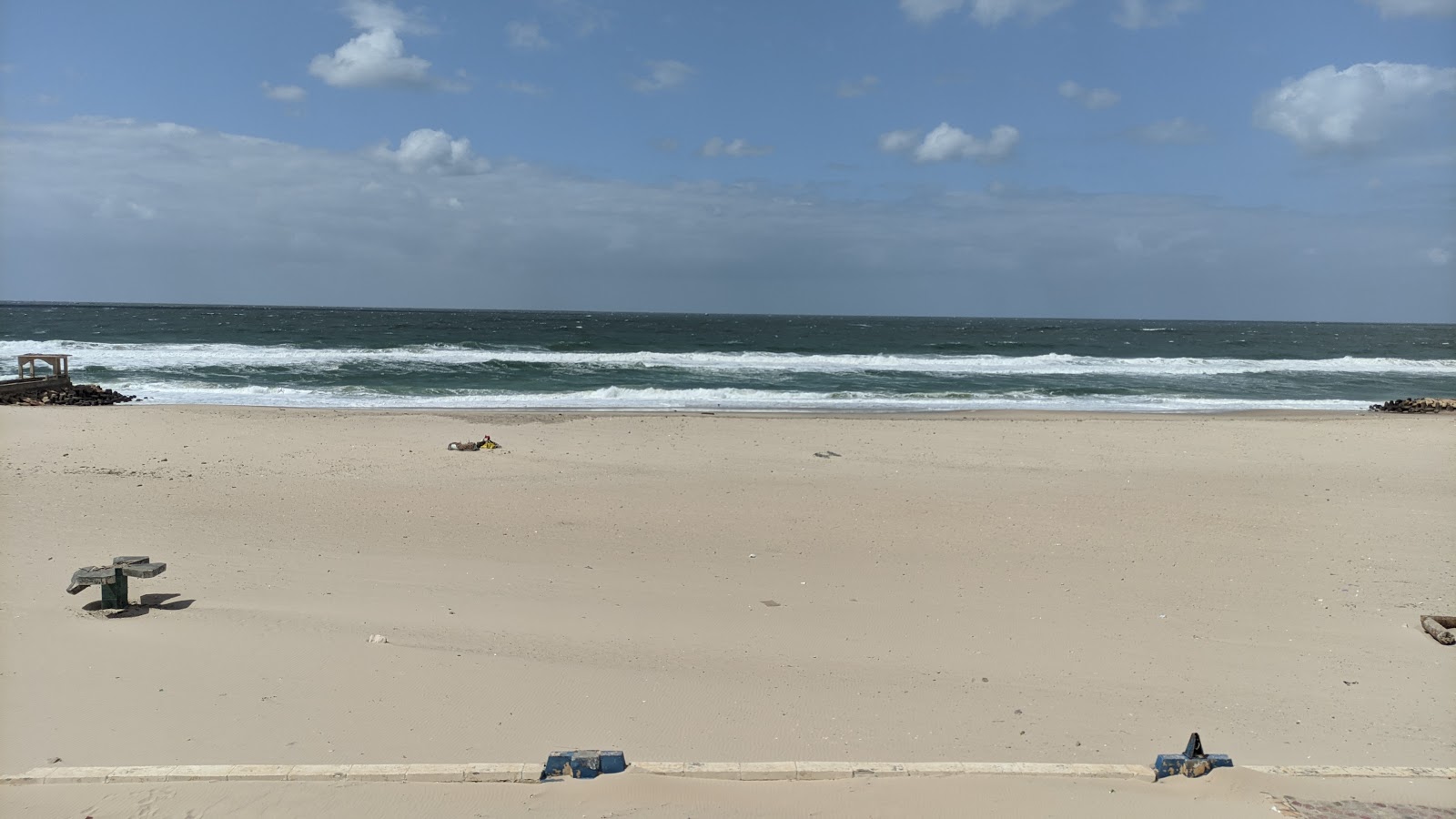 Valokuva El-Kersh Beachista. pinnalla kirkas hiekka:n kanssa