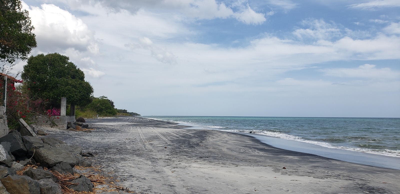 Foto av Juan Hombron Beach med grå sand yta