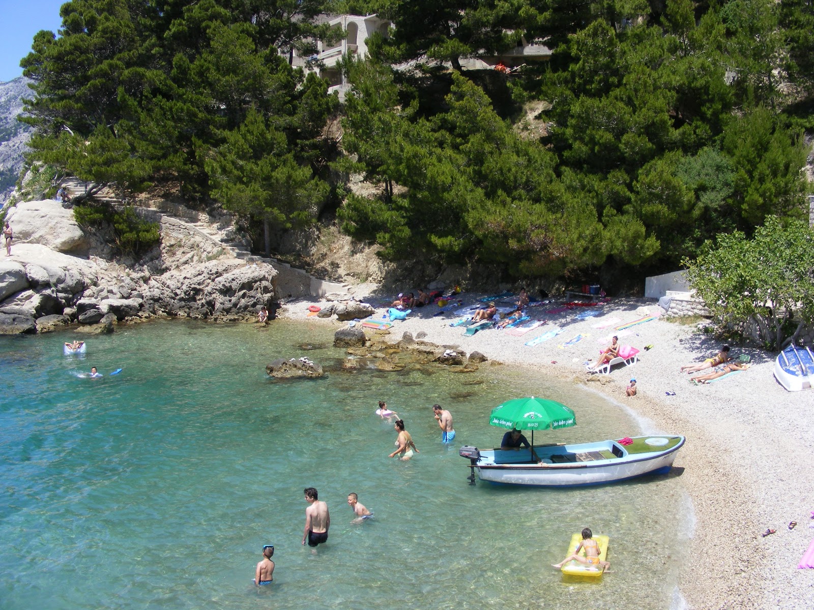 Foto von Jakirusa Strand von Klippen umgeben
