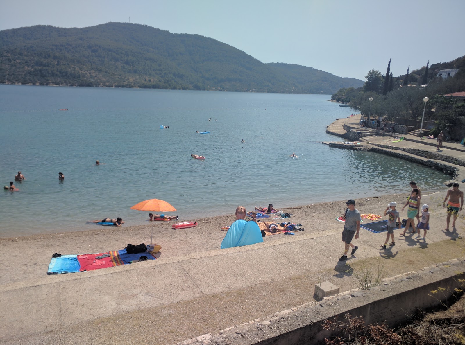 Foto af Plitvine beach bakket op af klipperne