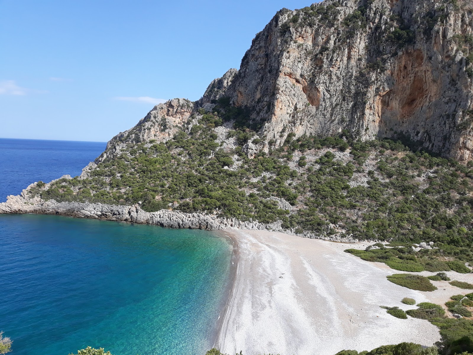Photo de Damos beach protégé par des falaises