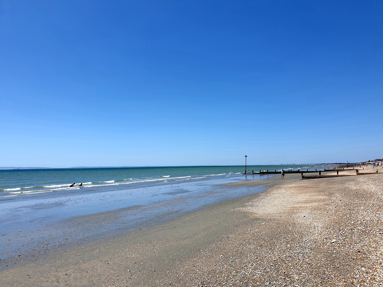 Foto de East Wittering beach com areia clara e seixos superfície