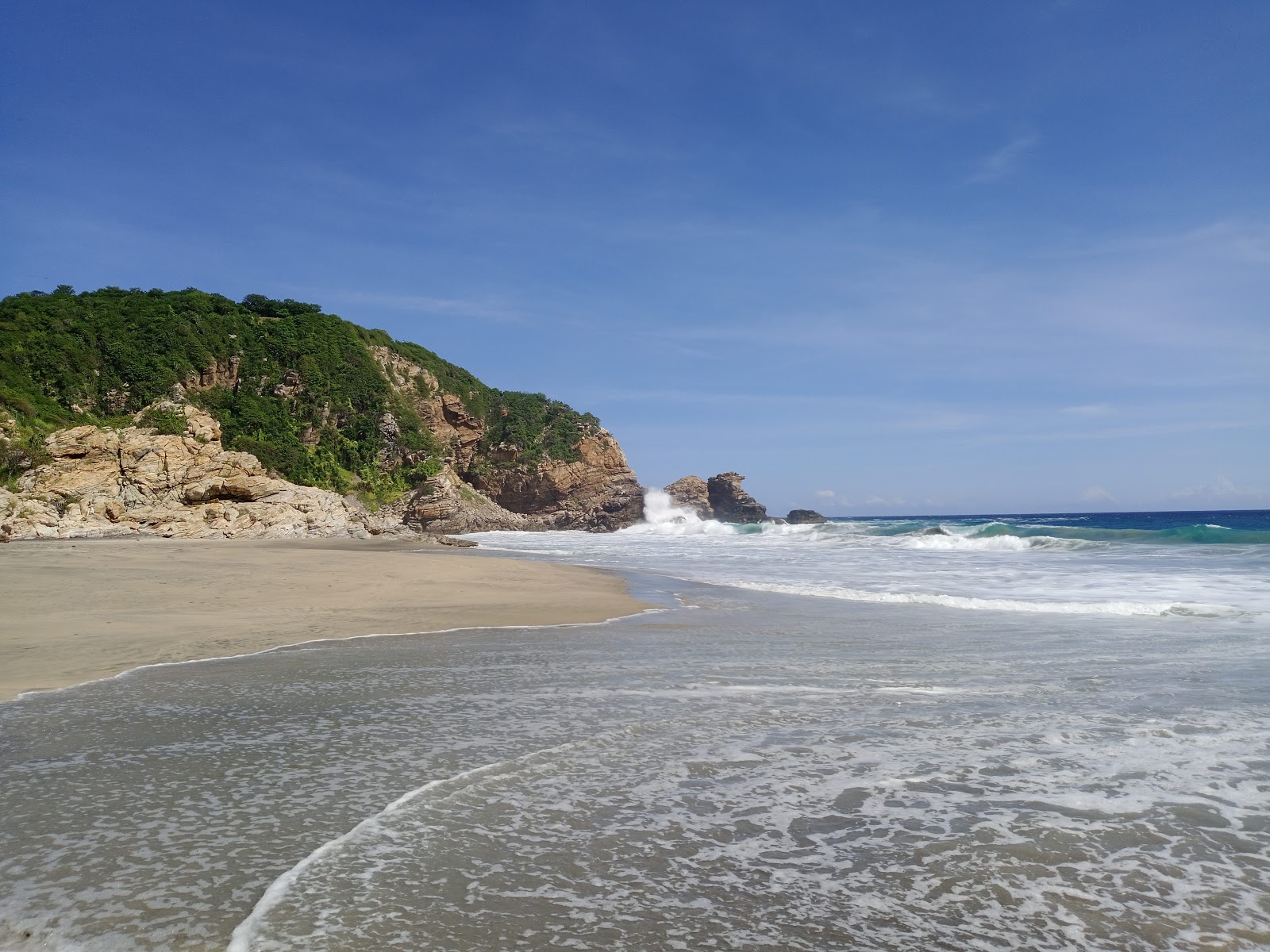 Foto di Playa La Ventanilla con una superficie del sabbia pura grigia