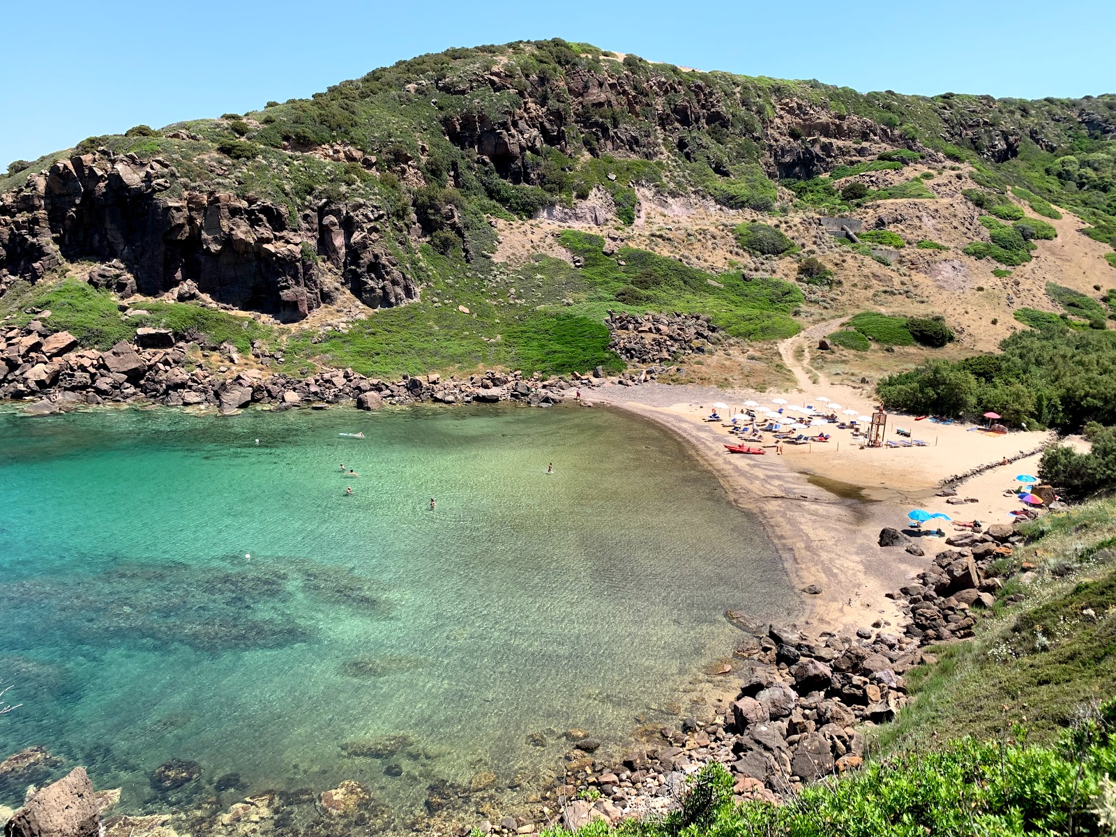 Foto de Cala Ostina com areia preta e seixos superfície