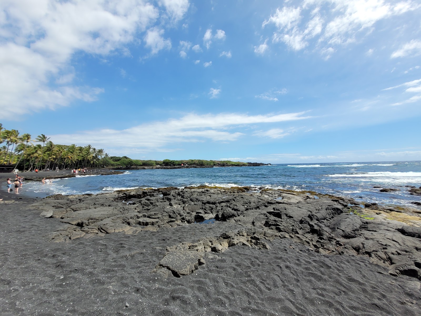 Foto av Punalu'u Beach omgiven av klippor