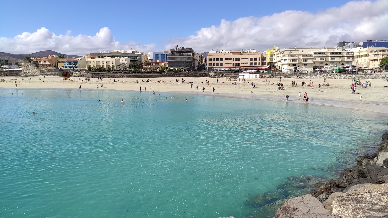 Foto de Playa Chica com areia fina e brilhante superfície