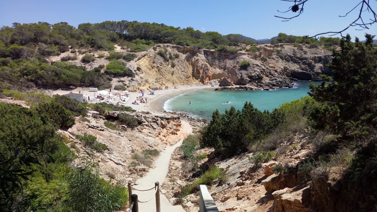 Photo of Cala Codolar with brown sand &  rocks surface