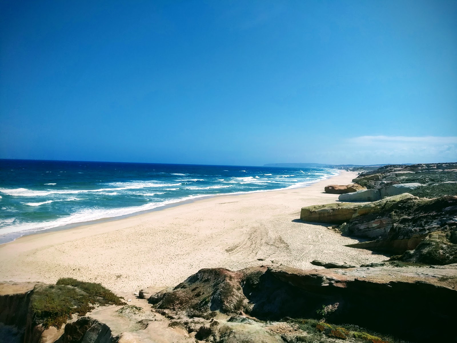 Fotografie cu Praia da Almagreira cu o suprafață de apa pură turcoaz