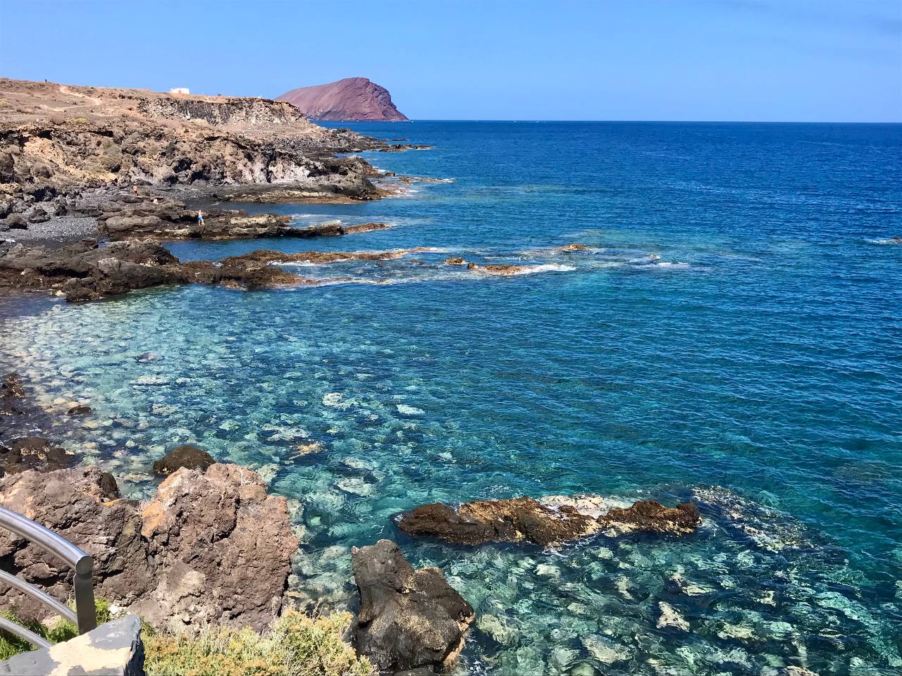 Foto von Playa Y Piscinas Naturales umgeben von Bergen