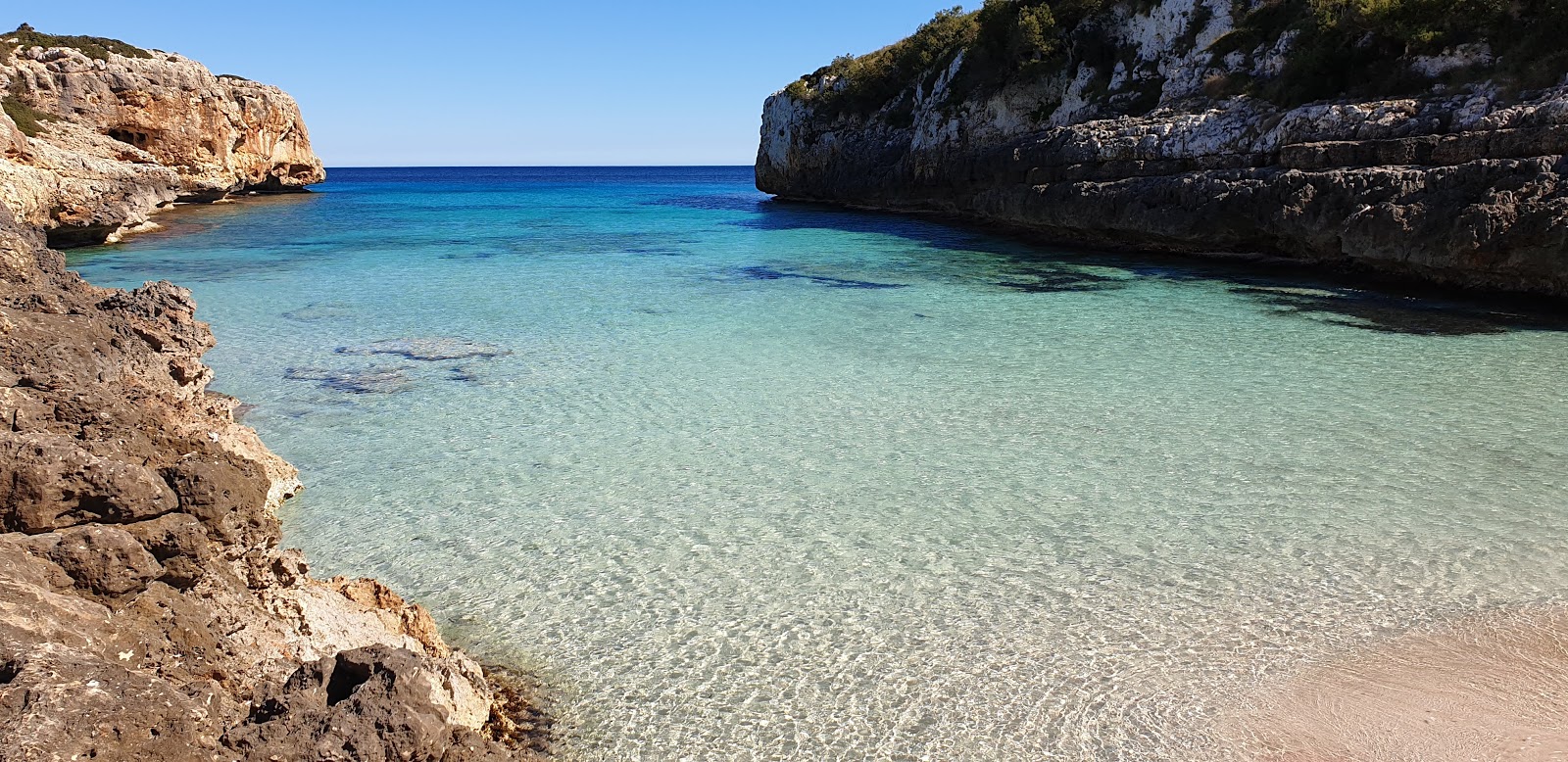 Foto de Beach Cala Sequer con brillante arena fina superficie