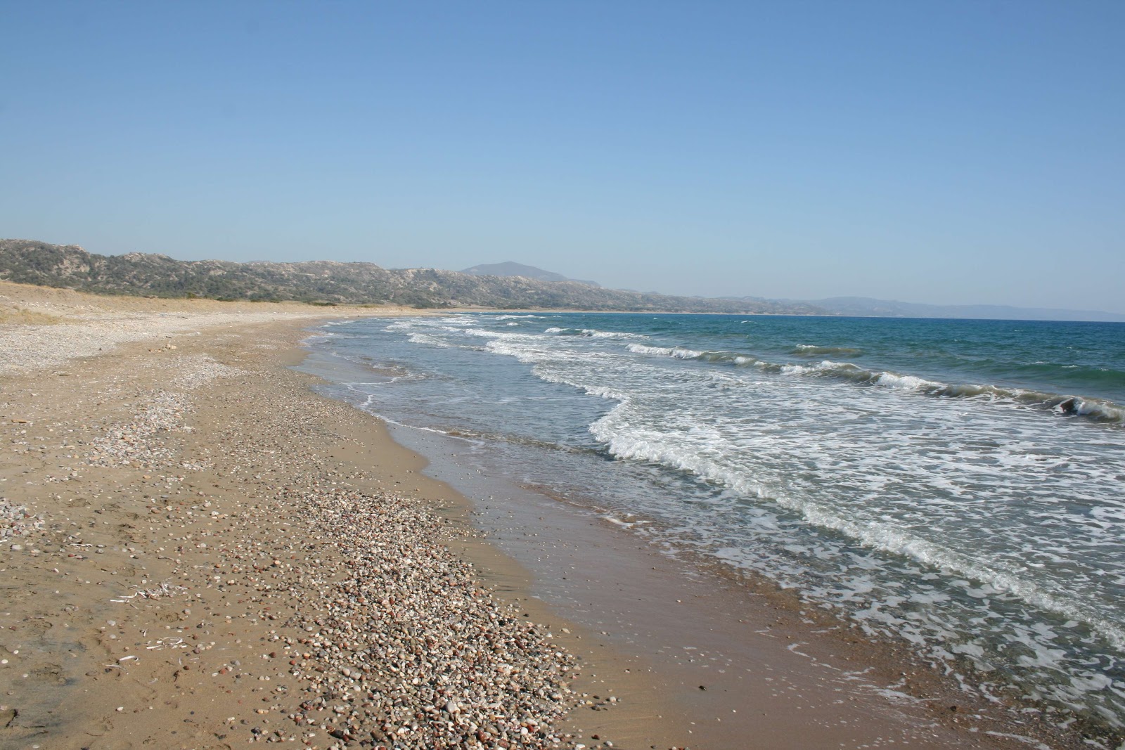Foto av Paralia Apolakia med musta hiekka ja kivi yta