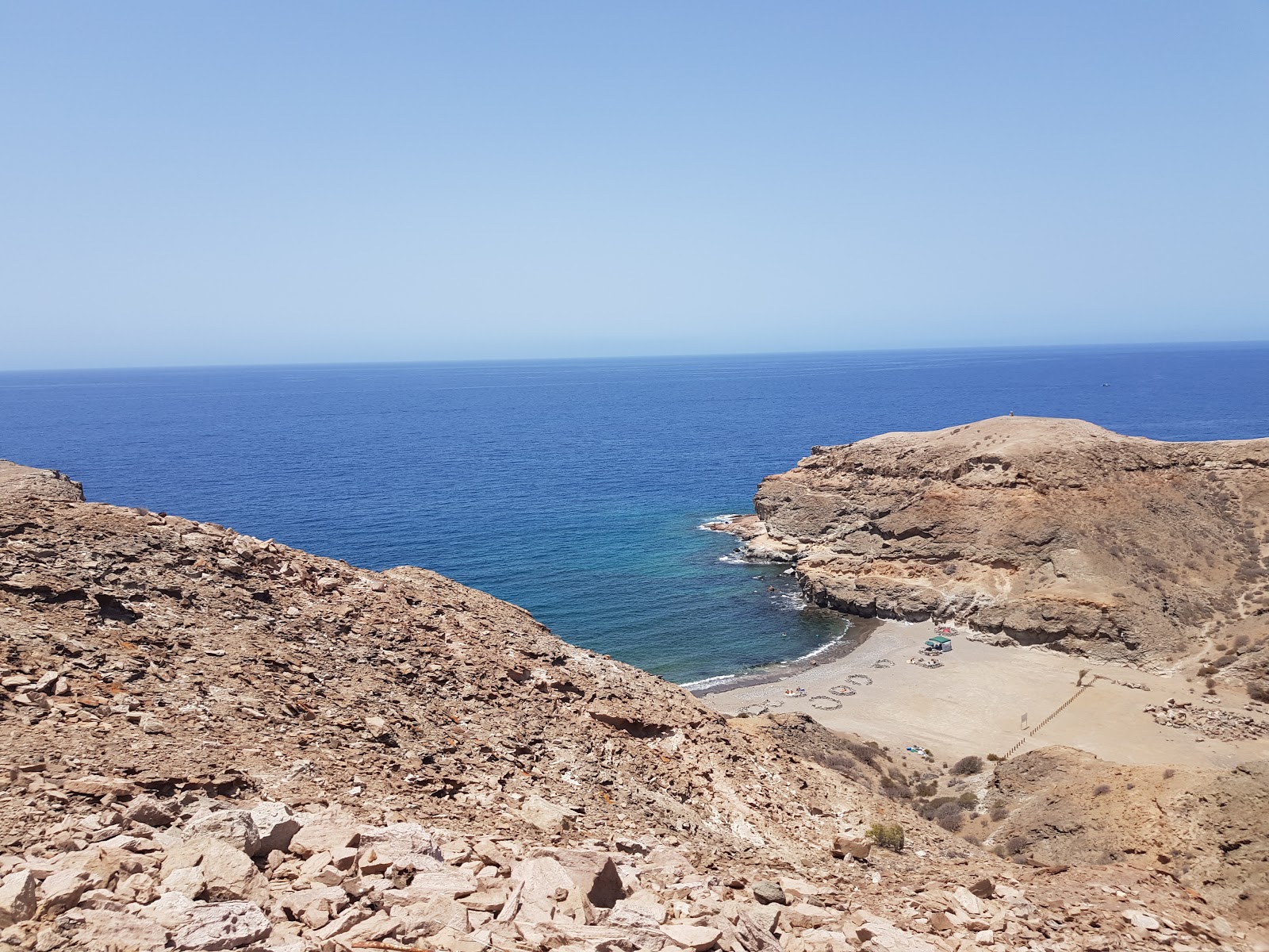 Foto de Playa Medio Almud com areia marrom e pedras superfície