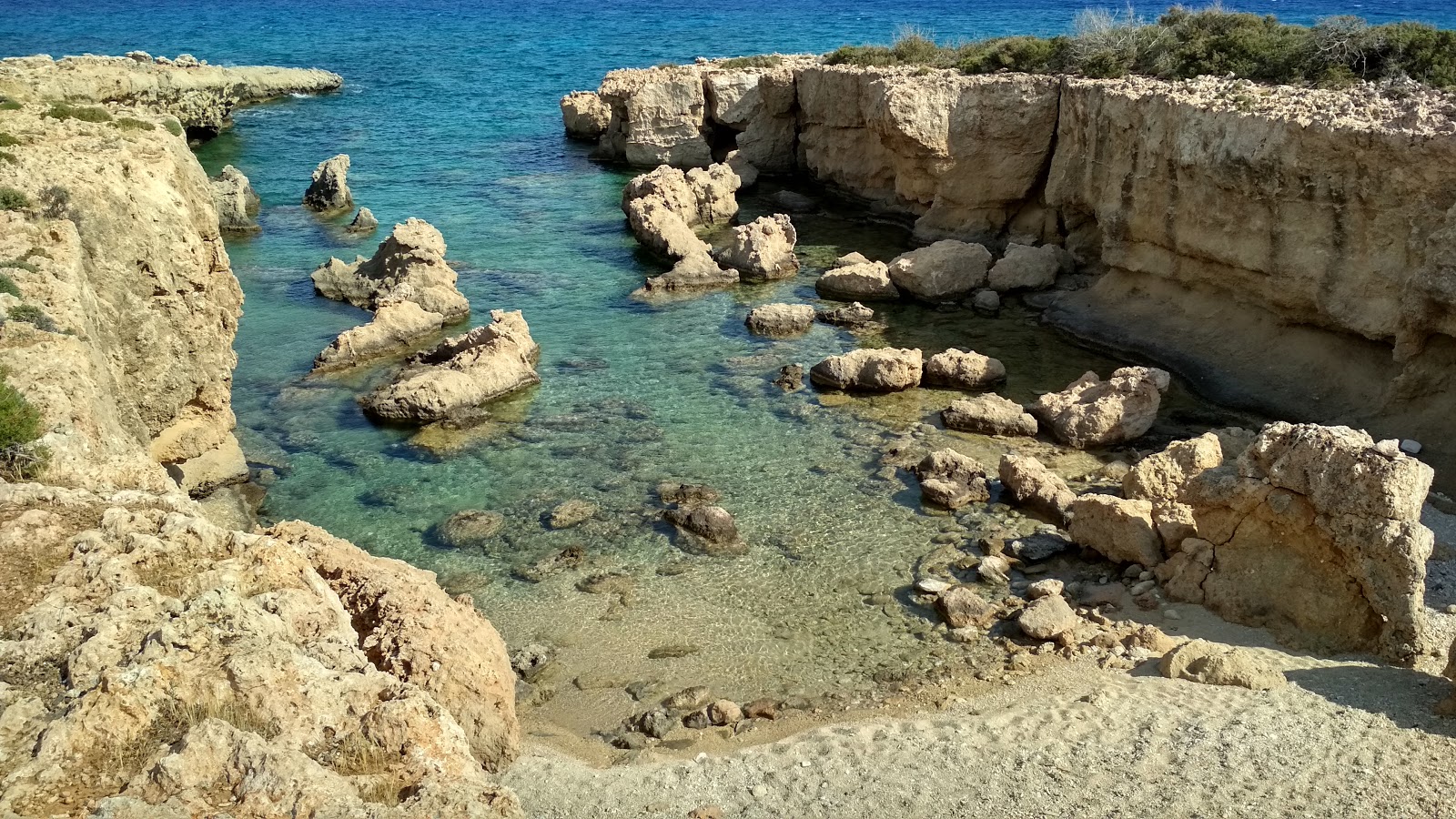 Foto di Pouliou beach con una superficie del sabbia beige e rocce