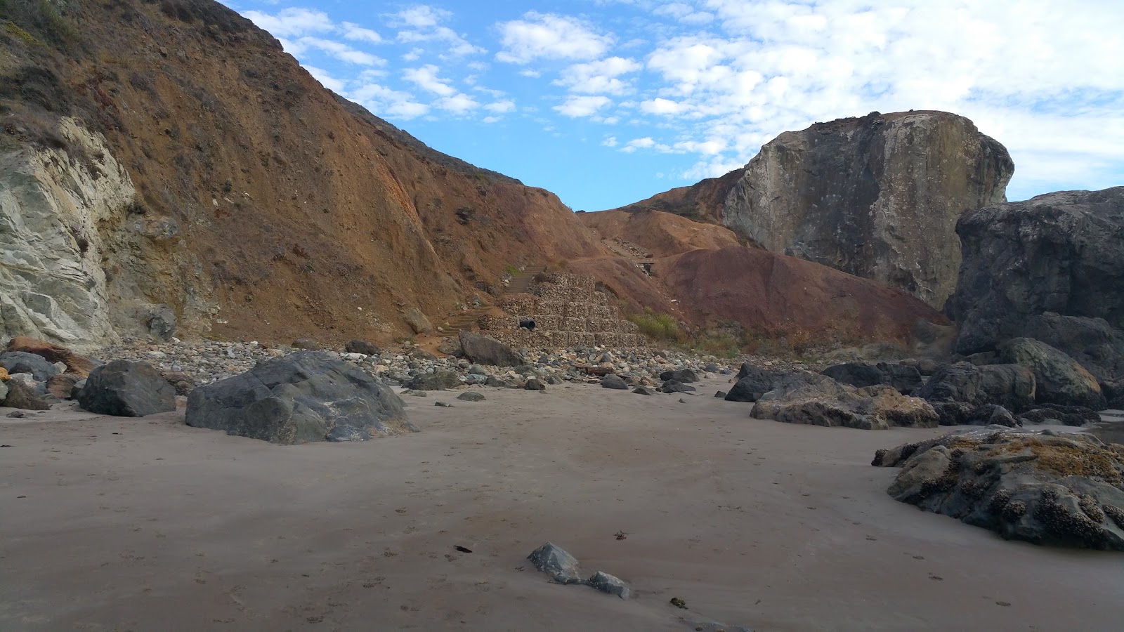 Foto af Red Rock Beach bakket op af klipperne
