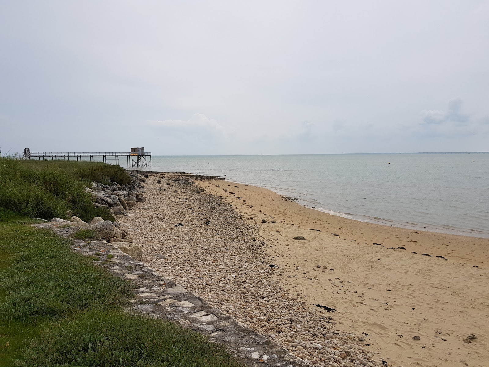Valokuva Plage aux Coquillagesista. pinnalla beige-kuorihiekkaa:n kanssa