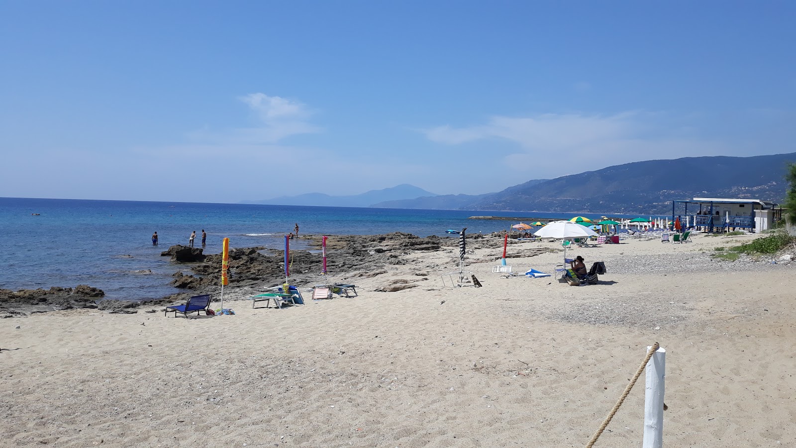 Foto av Spiaggia del Molo dei Francesi med beige sand och stenar yta