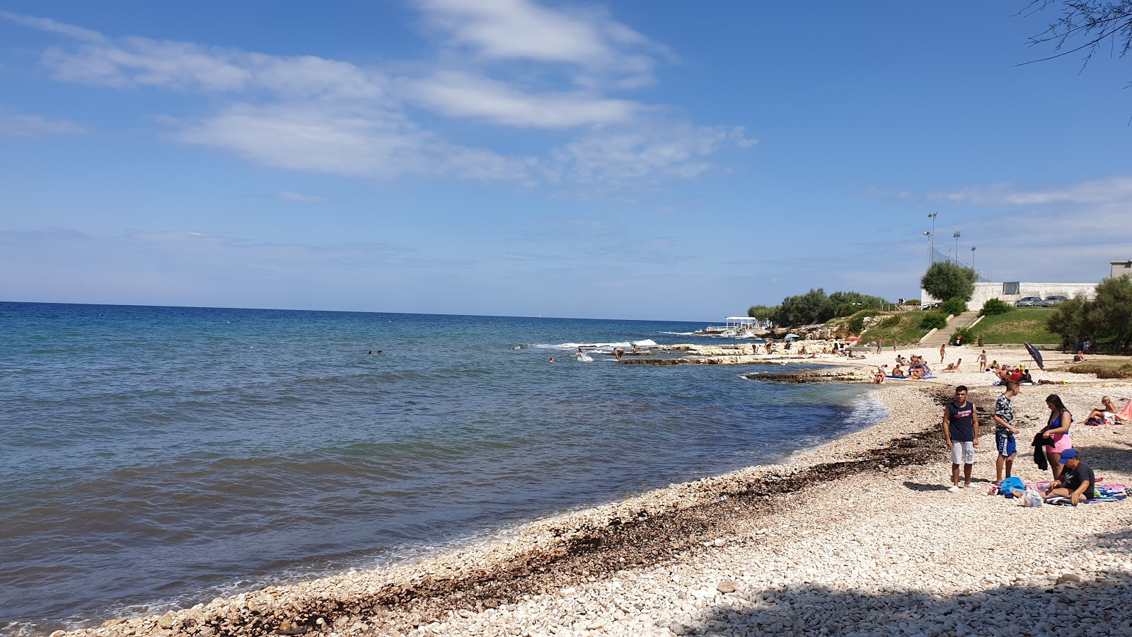 Foto van First Cala beach met stenen oppervlakte