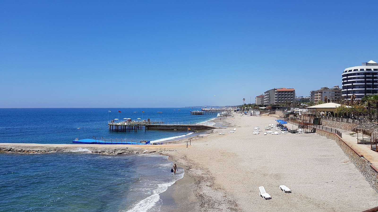 Foto av Turkler beach IV med musta hiekka ja kivi yta