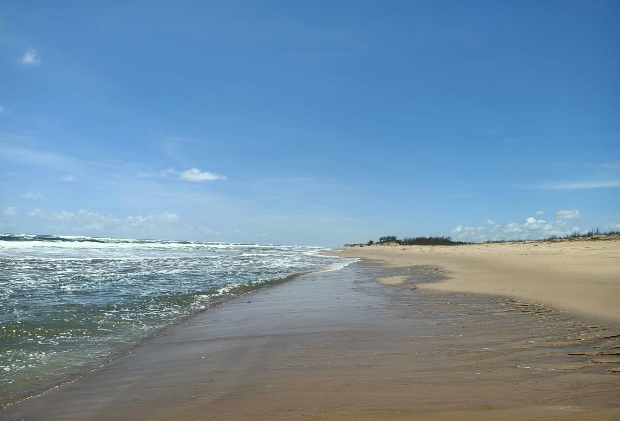 Foto de Singharapal Beach com areia fina e brilhante superfície