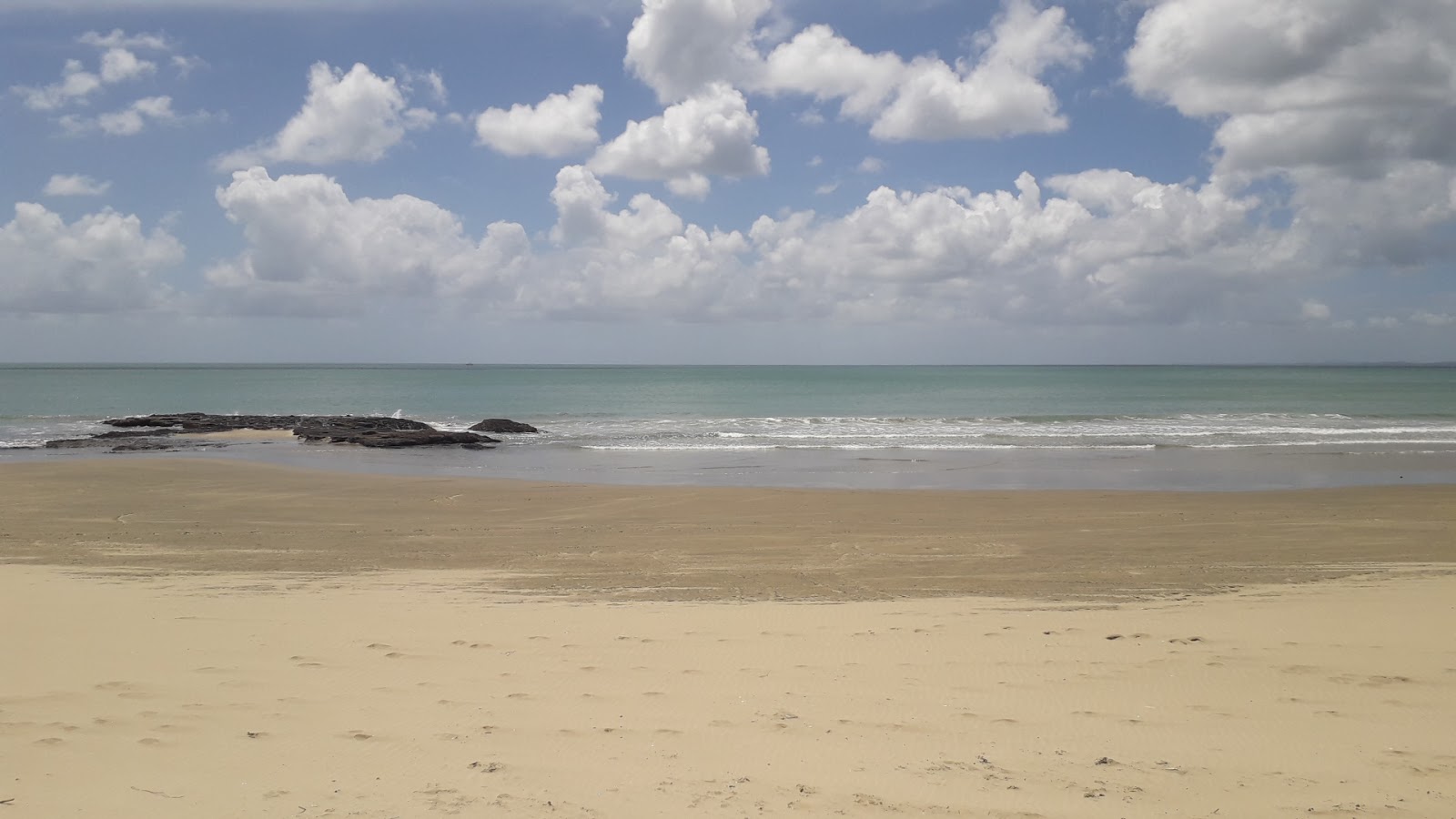 Foto af Ahipara Beach bakket op af klipperne