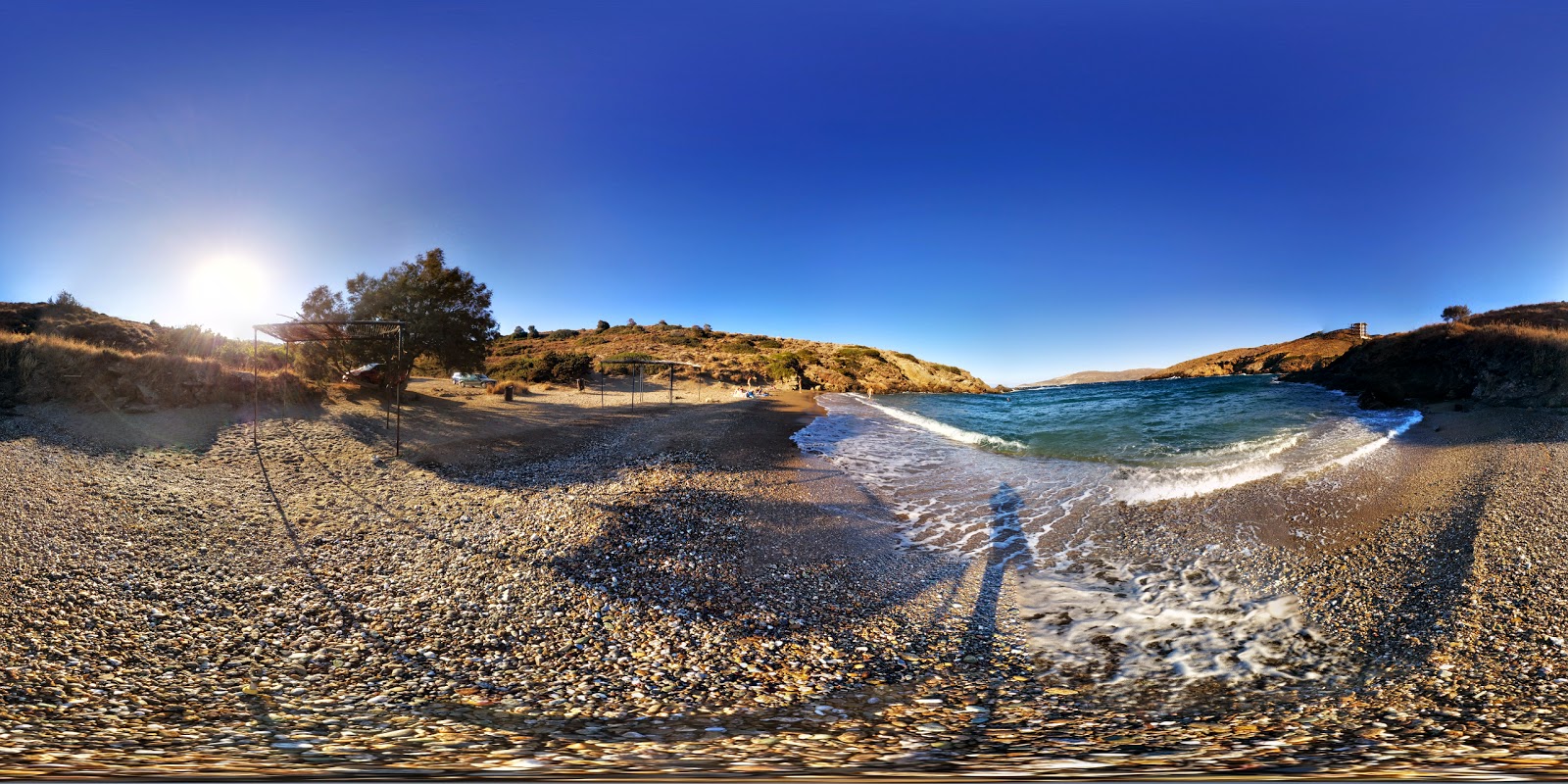 Foto av Panorama Mikrolimanou med musta hiekka ja kivi yta