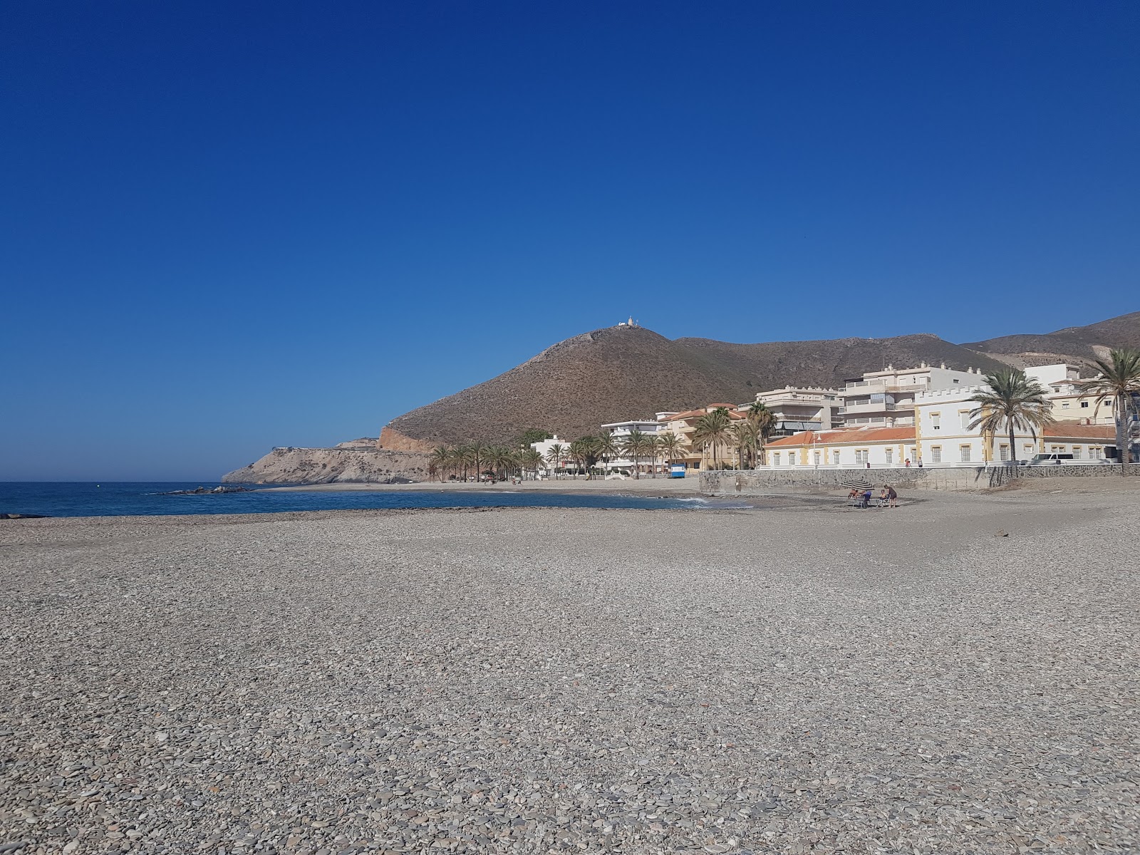 Foto von Playa Castell del Ferro mit kleine, graue kiesel Oberfläche