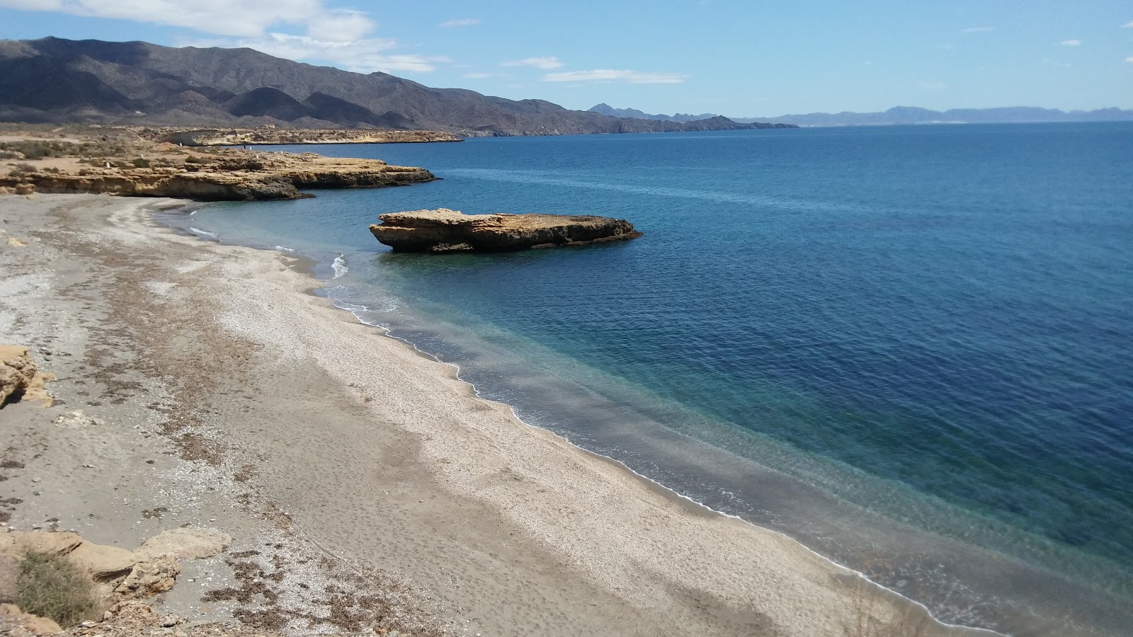 Photo of Playa de la Galera with gray shell sand surface