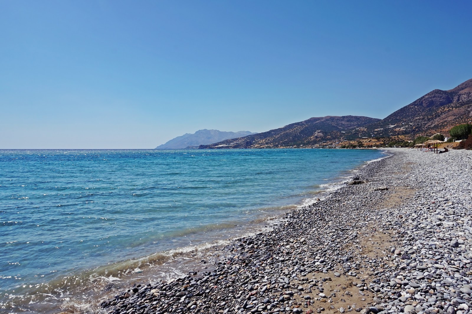 Foto di Monompouka beach con una superficie del sabbia beige e ciottoli