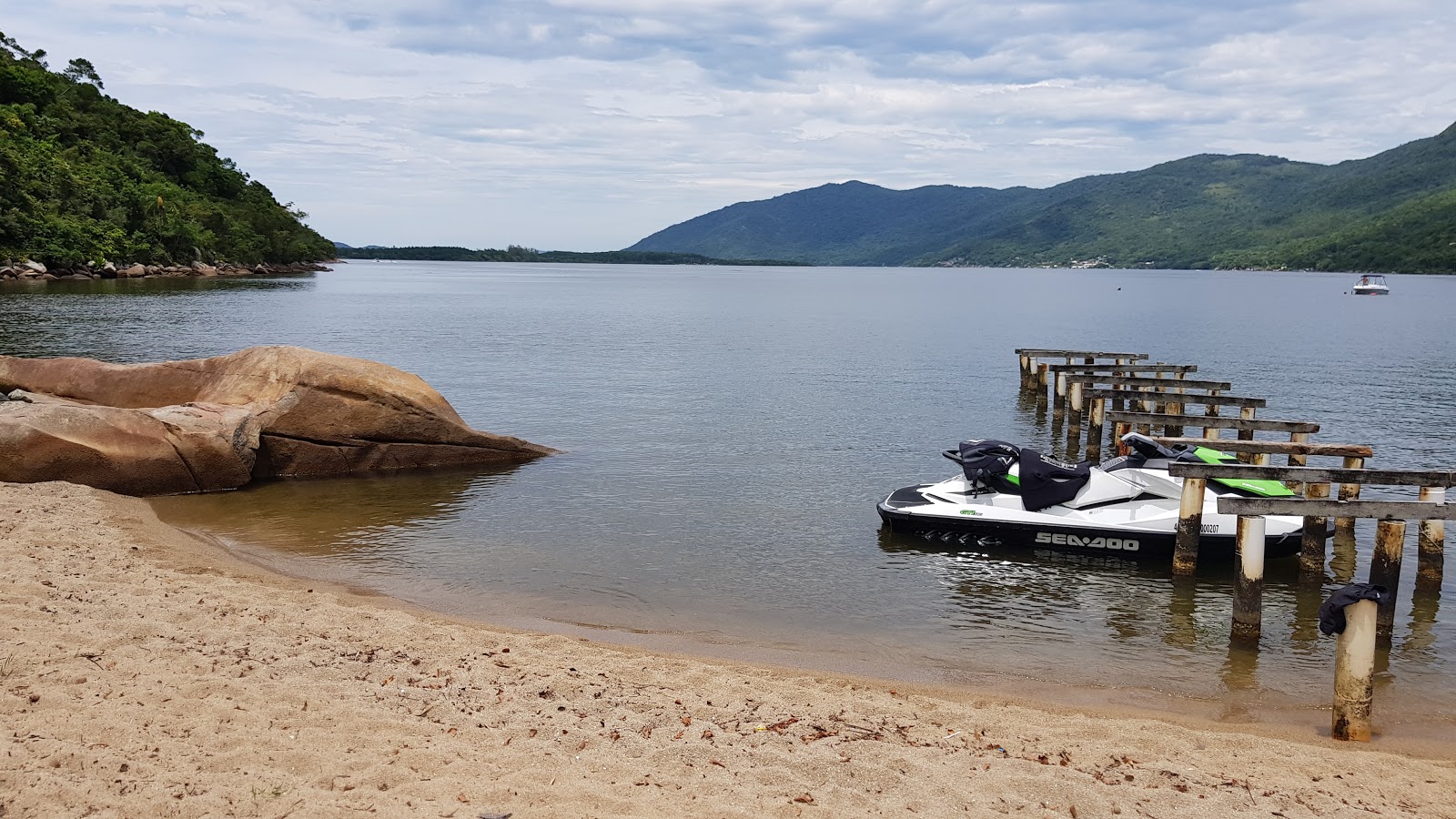 Fotografie cu Praia Costa do Saquinho sprijinit de stânci