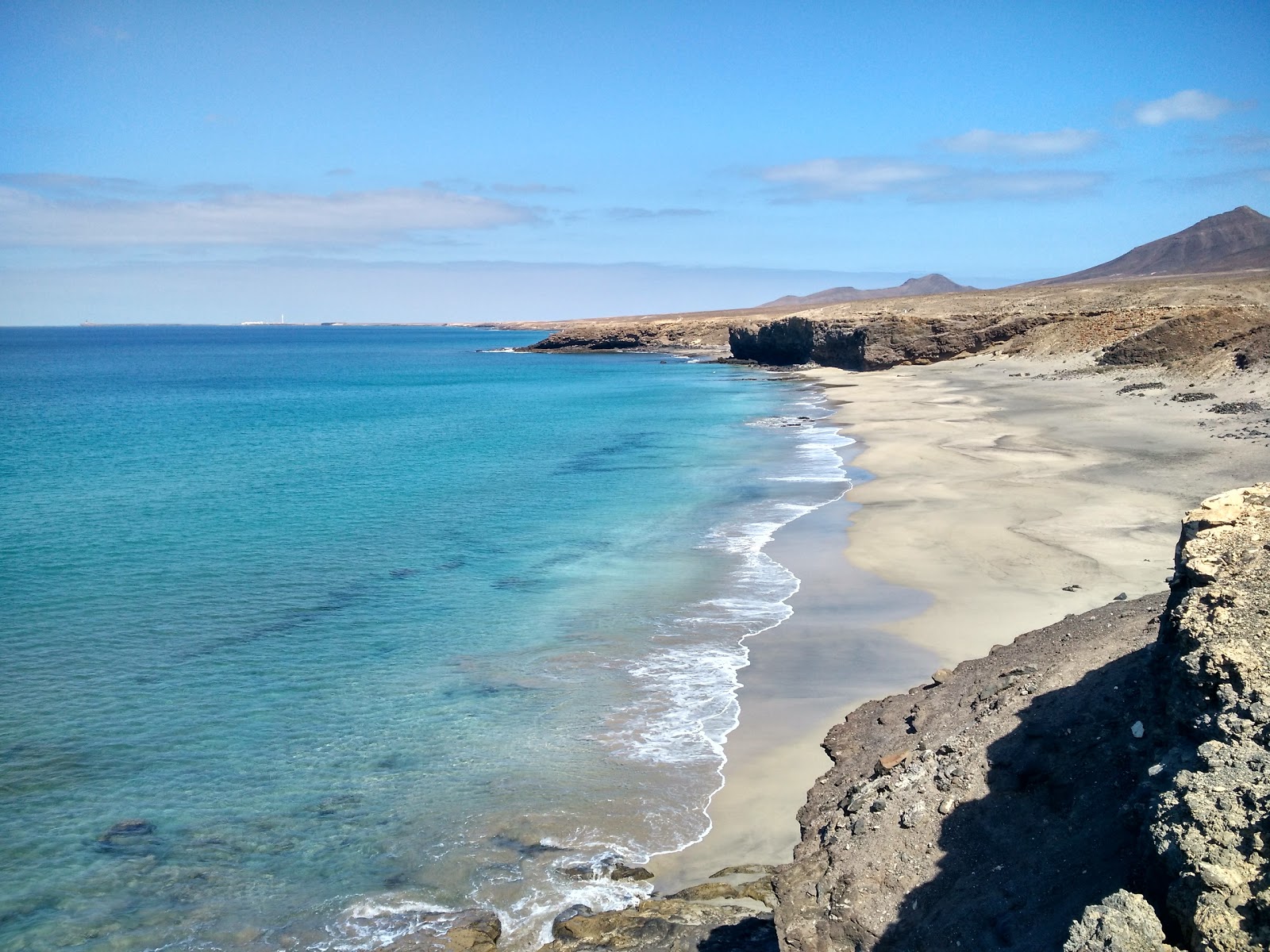 Photo de Playa Juan Gomez avec sable fin et lumineux de surface