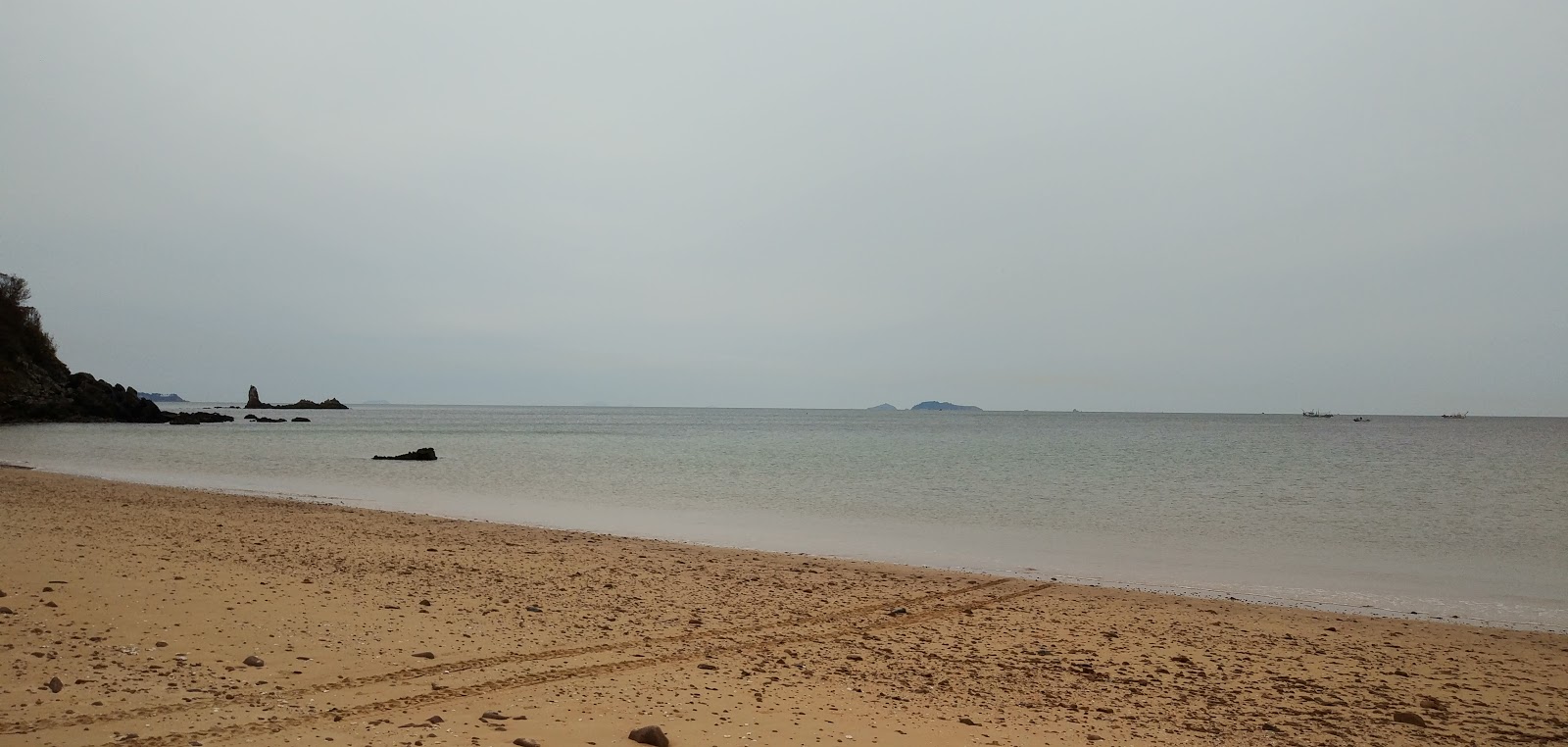 Foto van Duegi Beach met zand met stenen oppervlakte