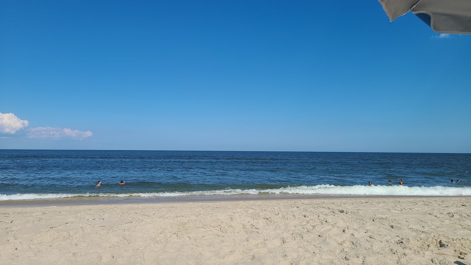 Photo of Sandy Hook Beach with turquoise pure water surface