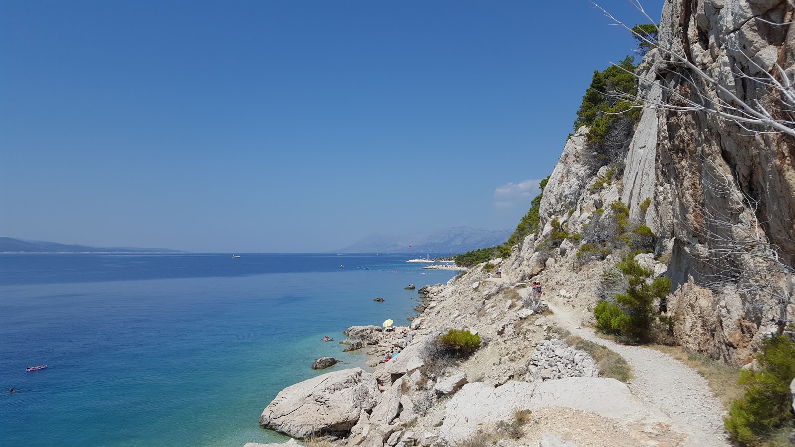 Foto av FKK beach med turkos rent vatten yta