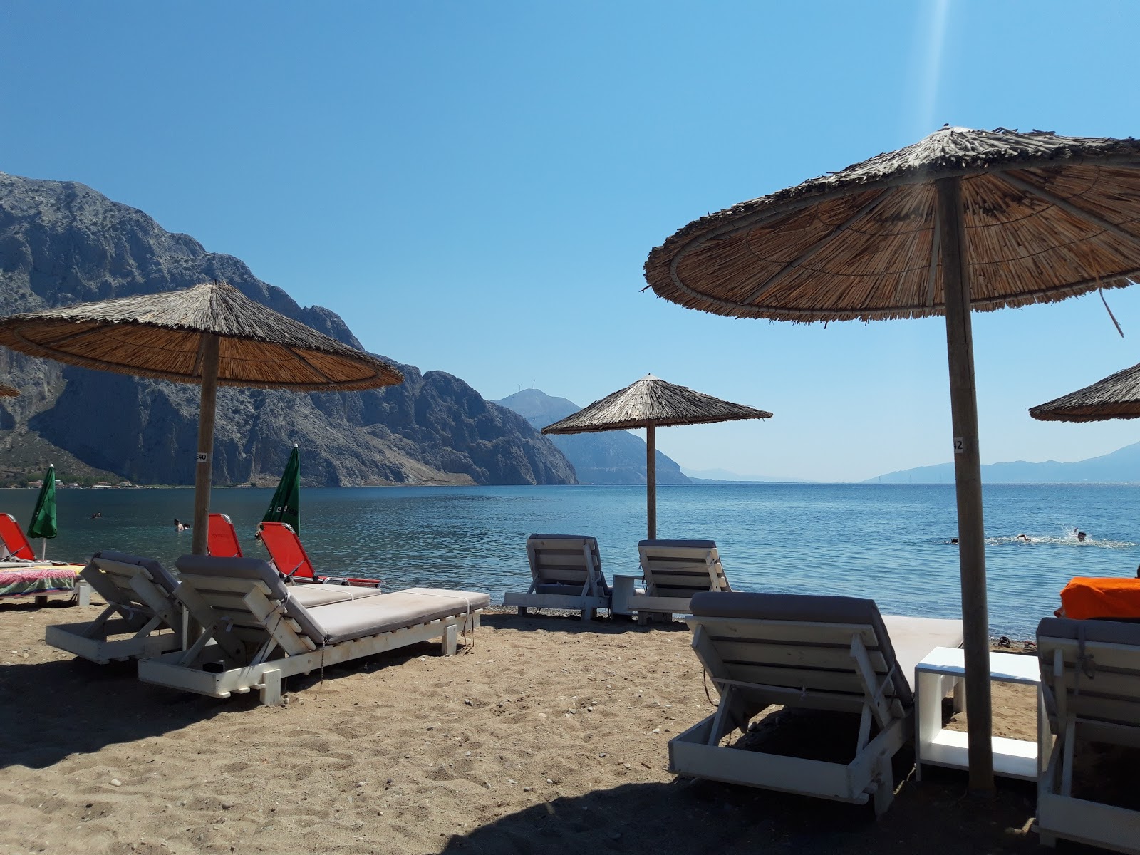 Foto von Nostros beach mit grauer sand Oberfläche