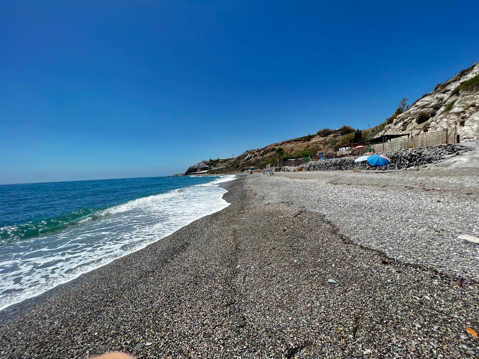 Foto di CalaJunco Beach con una superficie del piccoli ciottoli grigi