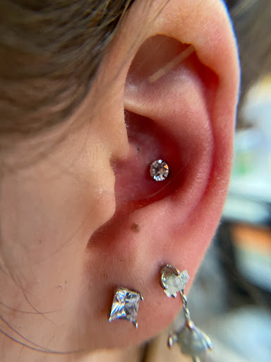 Explore tattoo ideas for side of stomach, creative tattoo ideas in Orange, available at Symbiosis Body Piercing