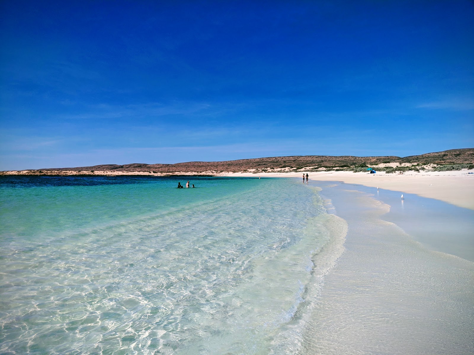 Foto av Turquoise Bay med beige sand yta