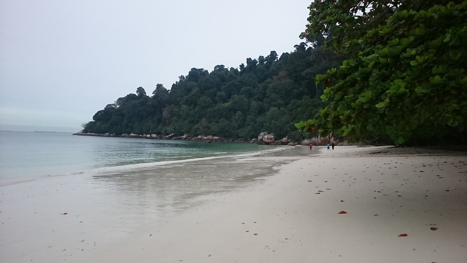 Foto von Teluk Segadas Beach umgeben von Bergen