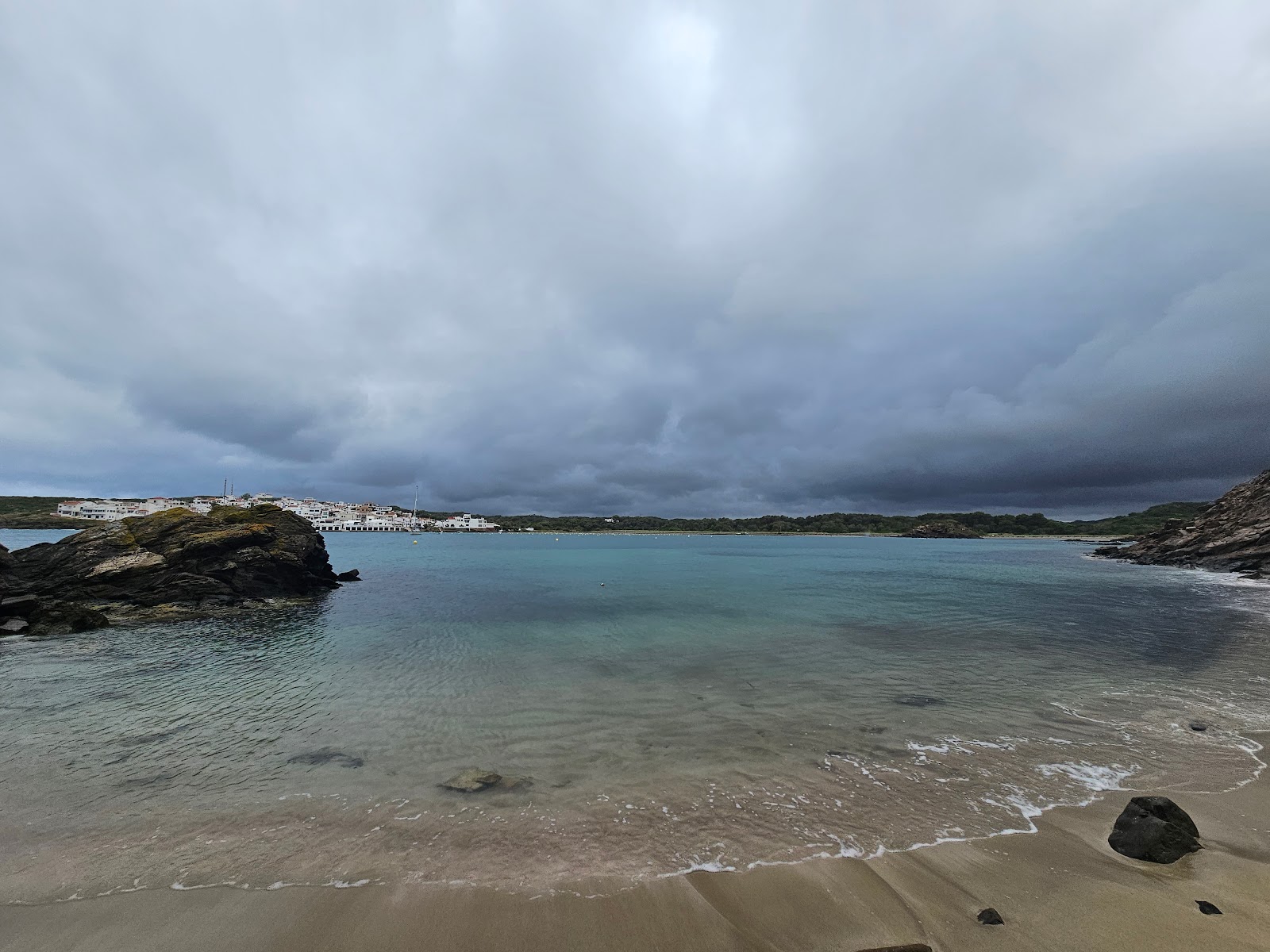 Fotografie cu Cala En Vidrier cu o suprafață de apă pură albastră