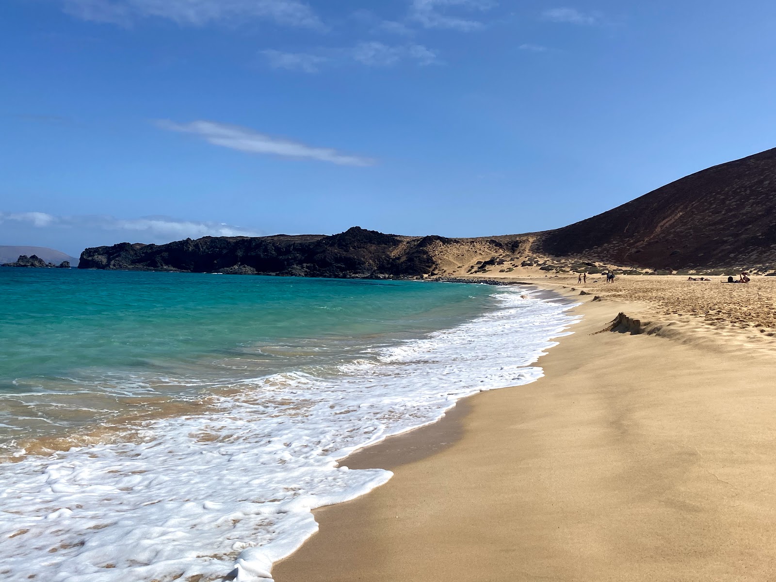 Foto di Playa de las Conchas con una superficie del sabbia beige fine