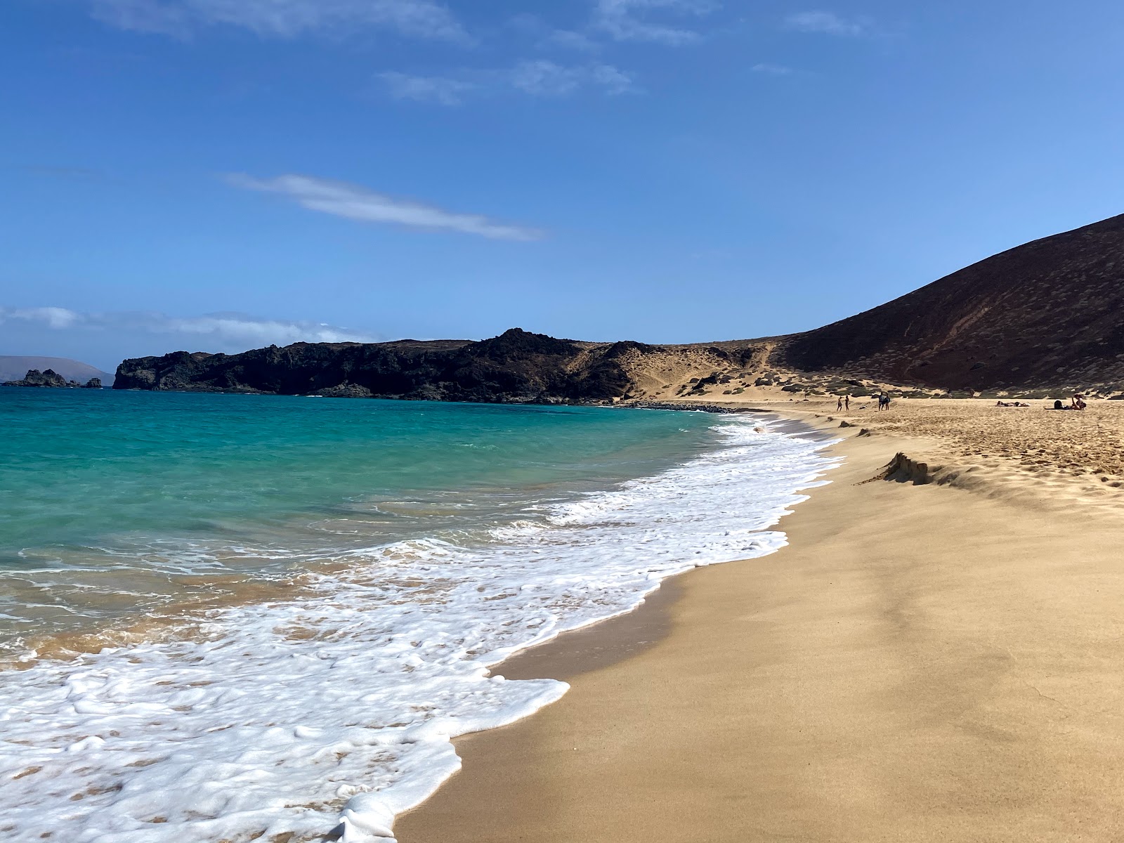 Foto de Playa de las Conchas com areia fina e brilhante superfície