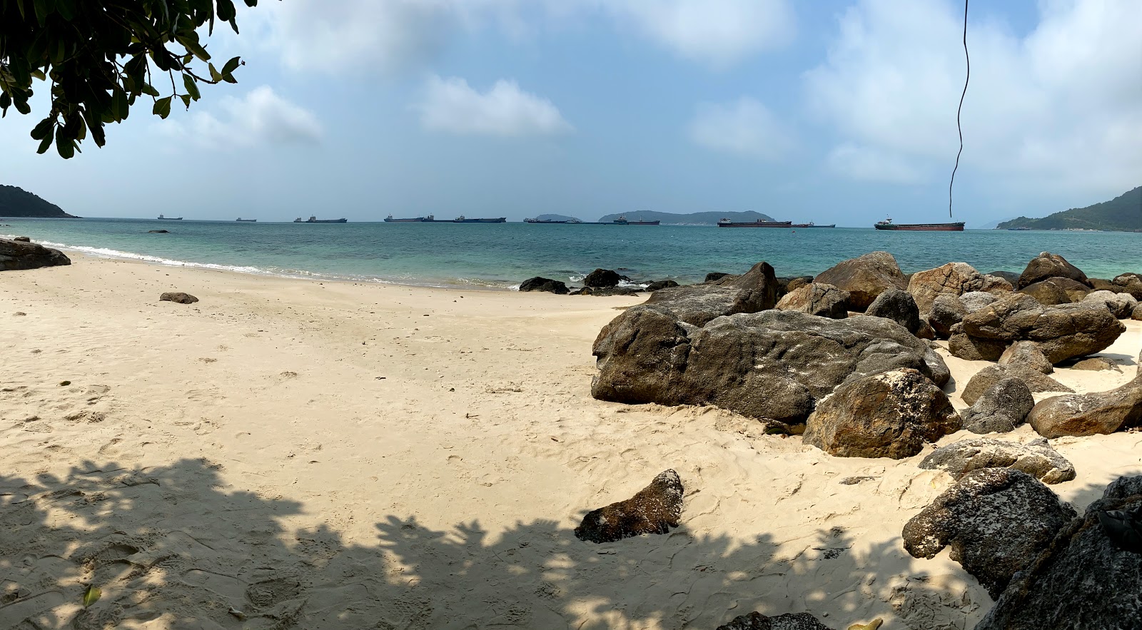 Foto af Perfume Beach bakket op af klipperne
