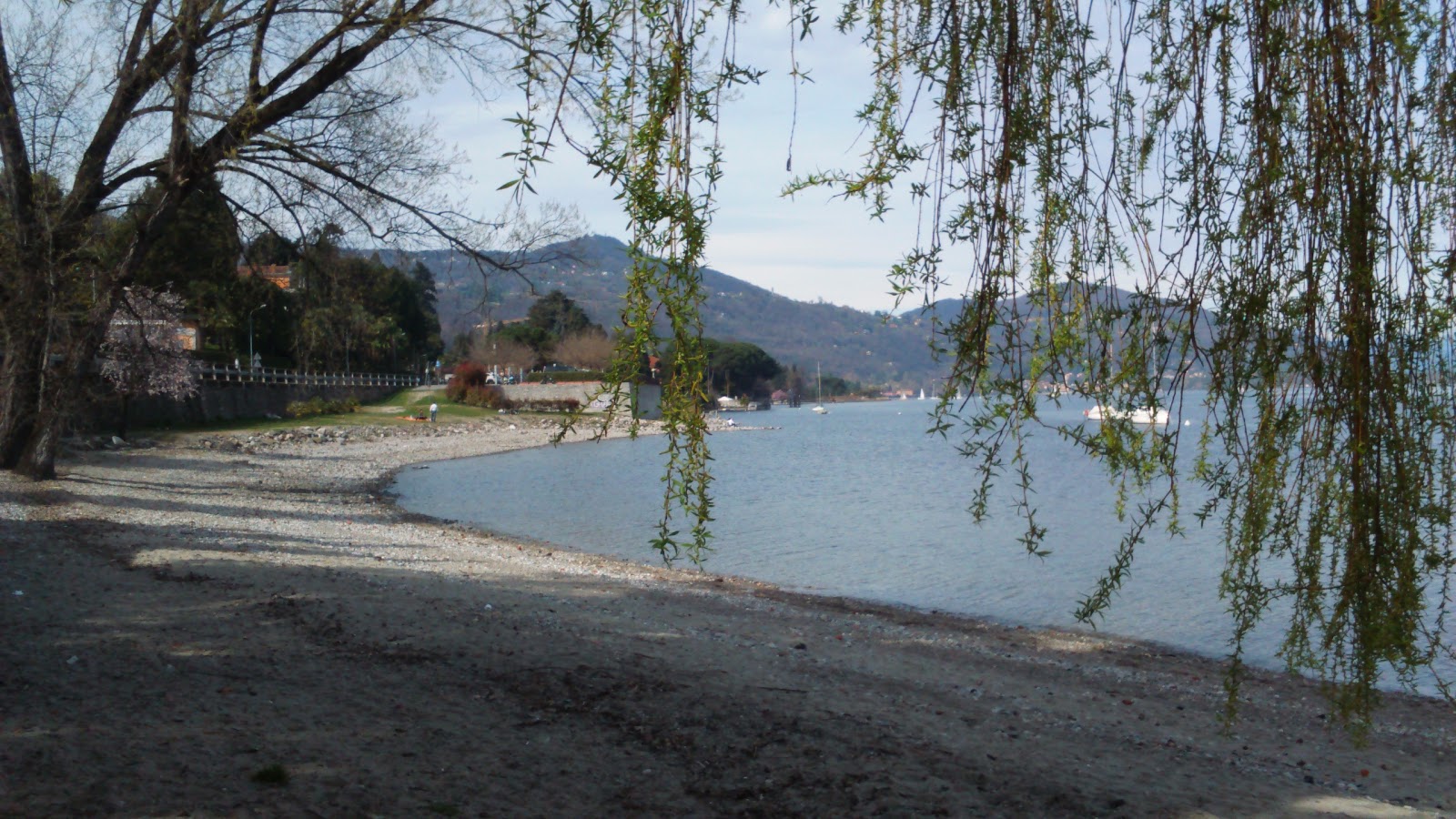 Foto di Spiaggia sul lago Maggiore con una superficie del sabbia grigia e rocce