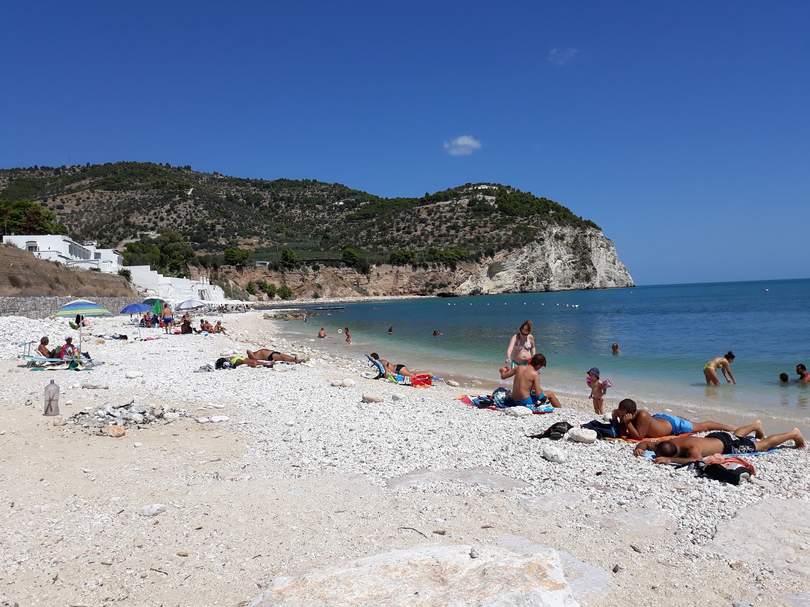 Foto von Tor di Lupo Beach mit beiger kiesel Oberfläche