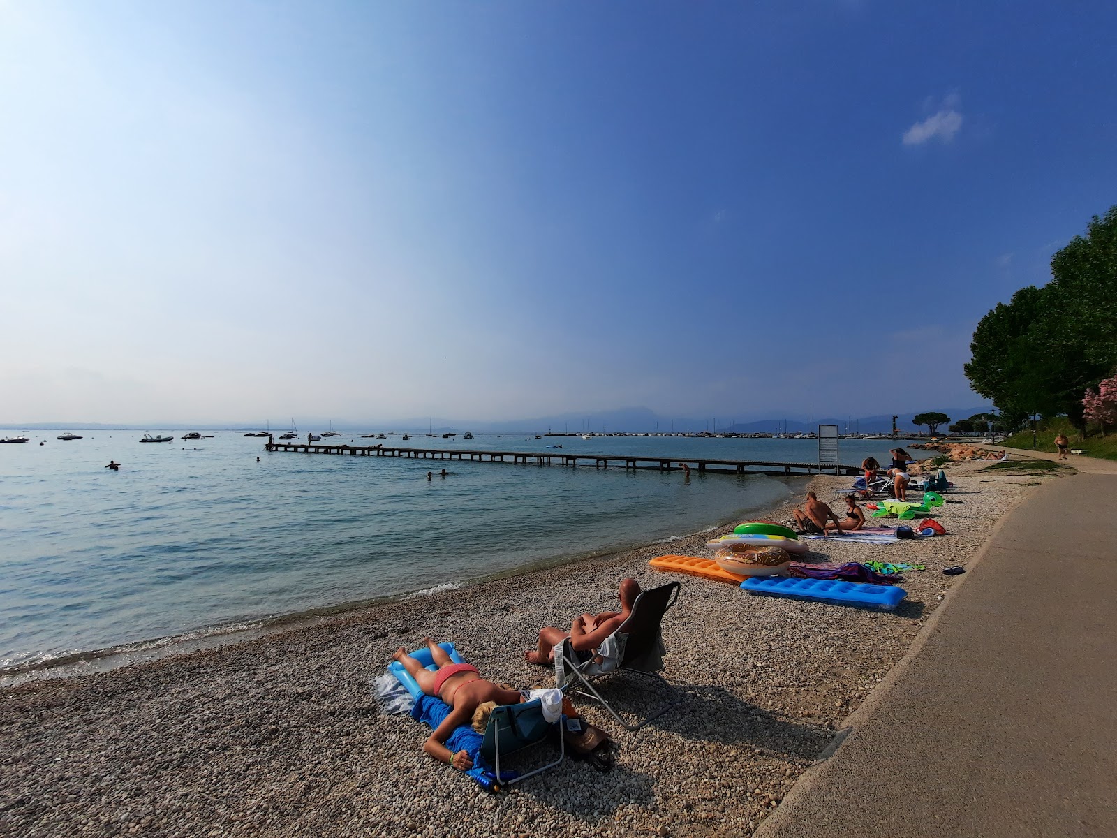 Foto di Spiaggia porto di Pacengo con una superficie del sabbia grigia e ciottoli