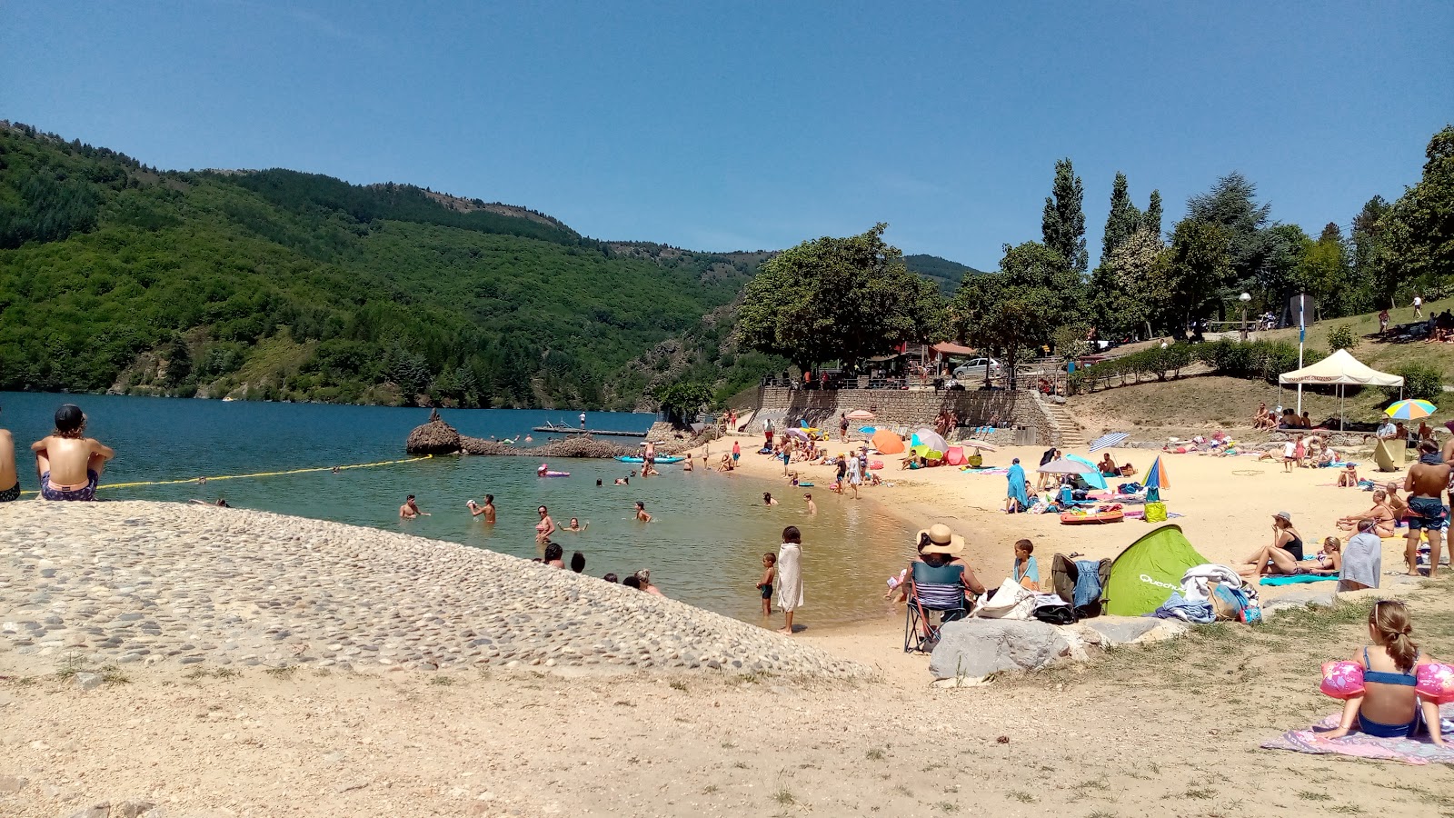 Foto di Plage du Lac de Villefort con una superficie del sabbia beige