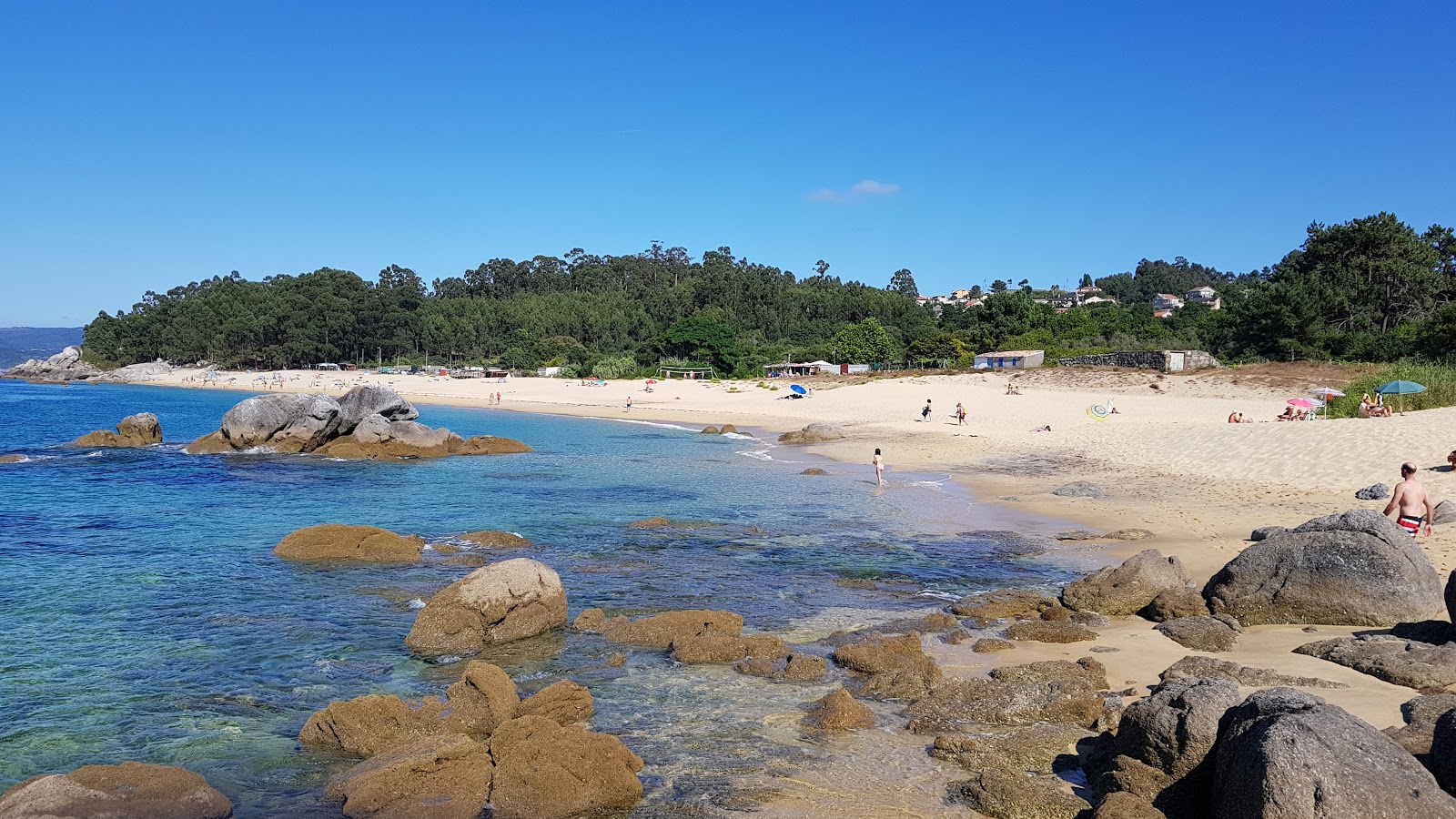 Foto di Praia de Tulla con una superficie del sabbia beige fine