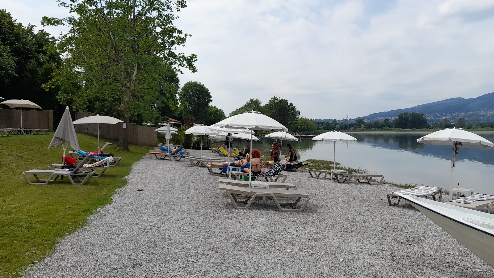 Spiaggia Lago di Pusiano'in fotoğrafı geniş bir kıyı şeridi ile birlikte